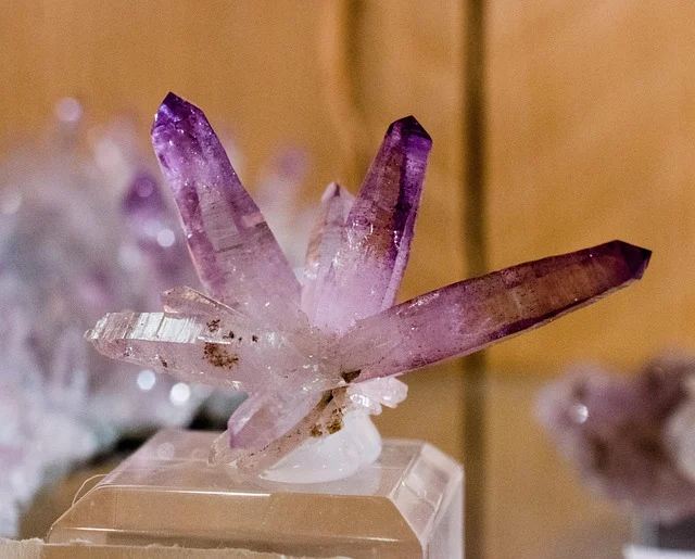 Gemstones and their meanings: A purple amethyst crystal cluster on a display stand