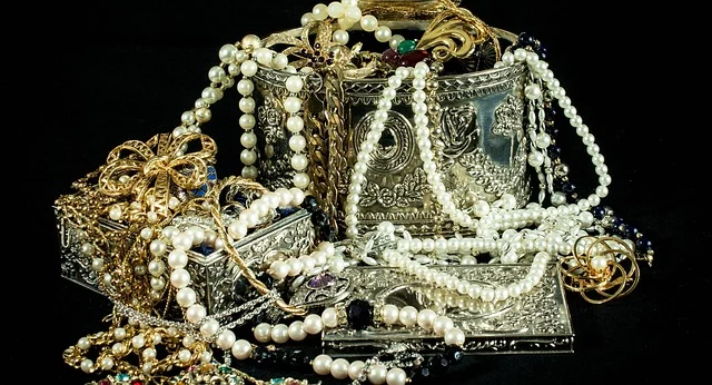 Silver jewelry boxes overflowing with pearl necklaces and gold jewelry