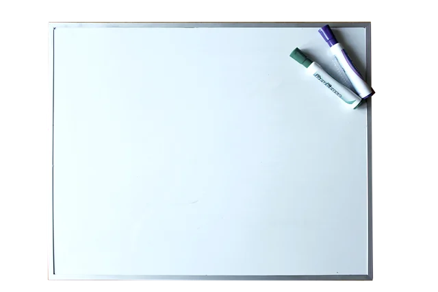 A blank whiteboard with two dry erase markers