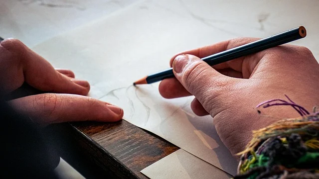 Hands sketching with a pencil on paper