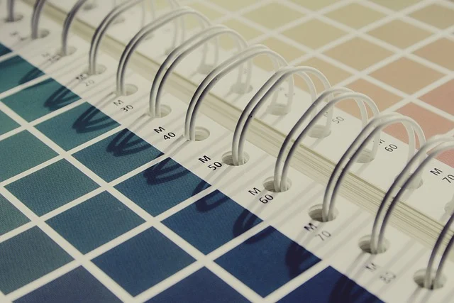 A spiral-bound color swatch book with printed color grids