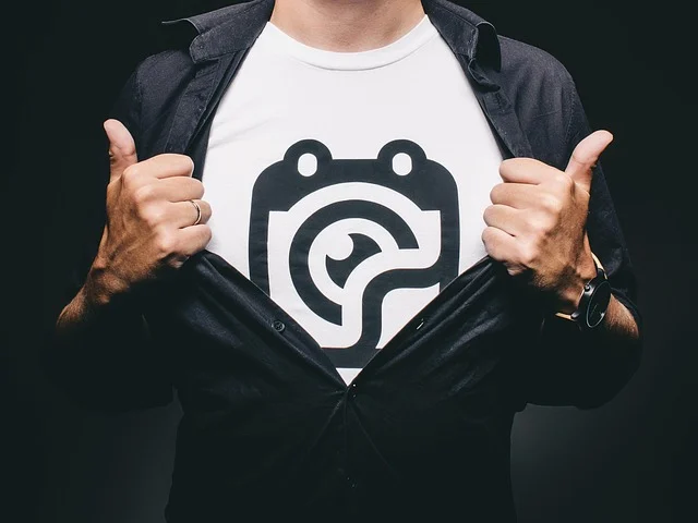 A man opening his black shirt to reveal a graphic t-shirt