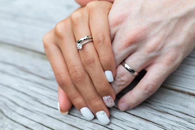 Brilliant earth mens wedding bands: A couple holding hands displaying their wedding rings