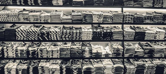 Shelves stacked with various folded t-shirts
