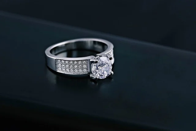 A silver ring with a large center diamond and pave diamonds