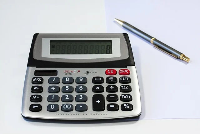 An electronic calculator and a pen on paper