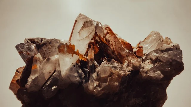 A raw crystal cluster with clear quartz and brownish mineral points