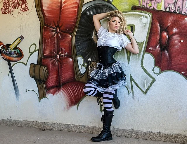 A woman in alternative fashion posing in front of graffiti art