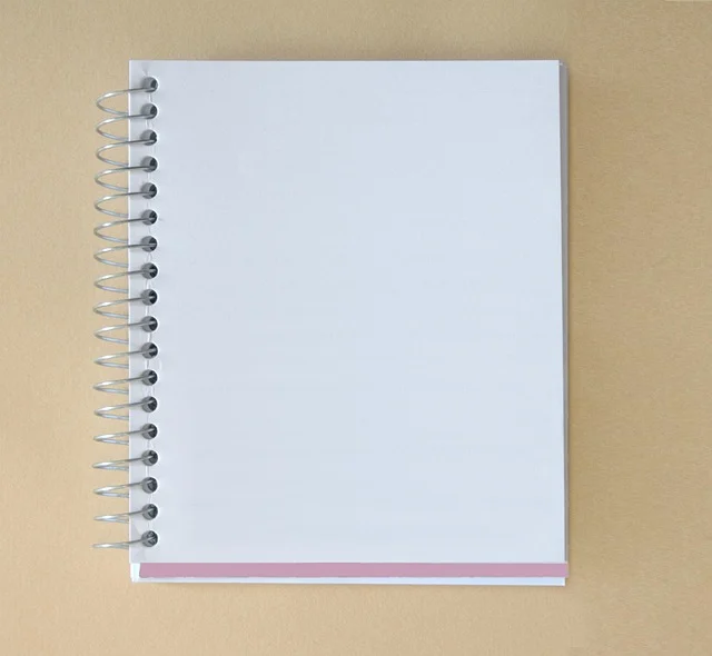 A blank spiral notebook on a beige background