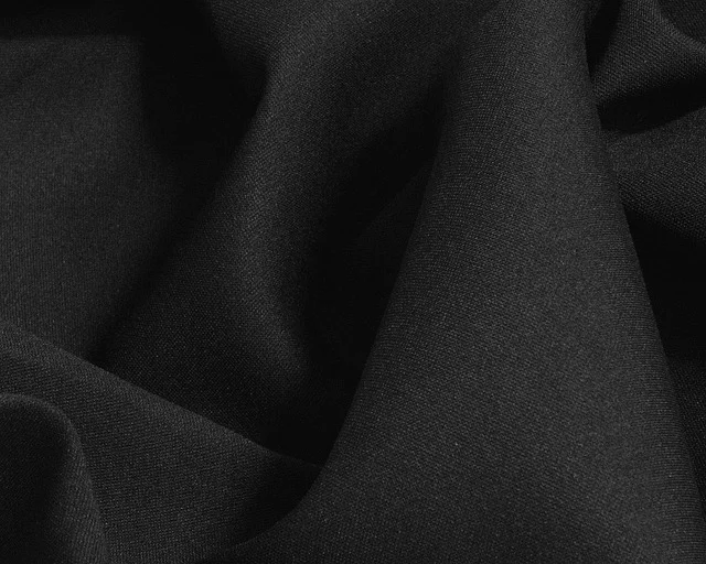 A close-up view of draped black fabric folds