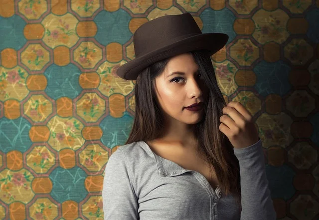 Asymmetrical top: A woman wearing a hat and a grey long-sleeved top