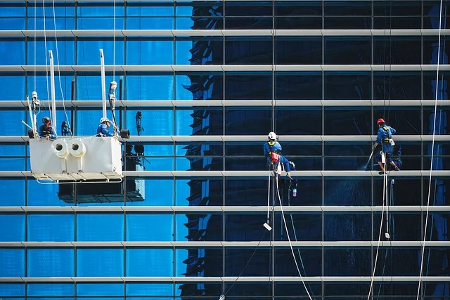 Window cleaners working on the glass facade of a tall building