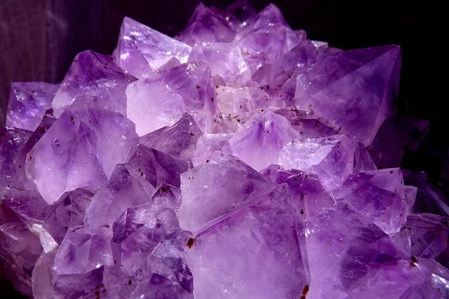 A close-up cluster of natural purple amethyst crystals