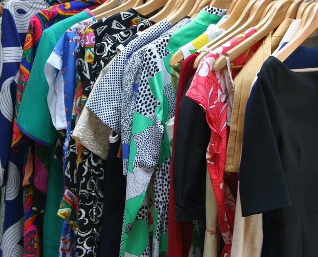 Various colorful clothes hanging on wooden hangers