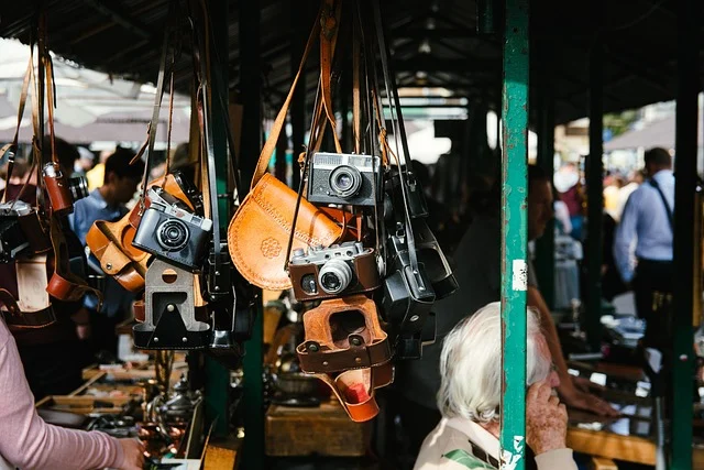 Vintage film cameras and leather cases hanging at a market stall