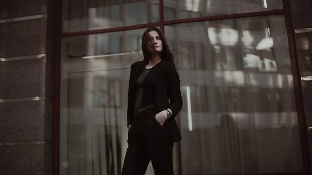 A woman standing outside wearing a stylish black blazer and trousers