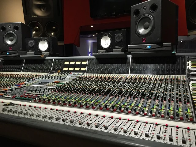 A professional mixing console and speakers in a recording studio