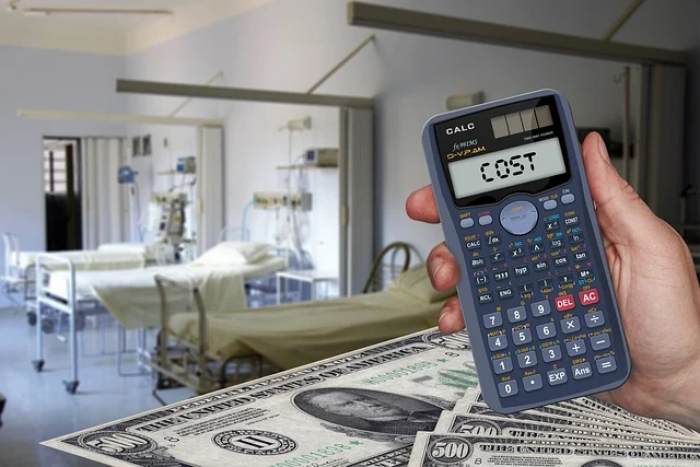Hand holding a calculator displaying COST with cash and a hospital background
