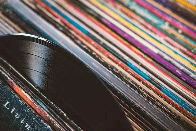 A vinyl record sticking out from a stack of colorful album covers