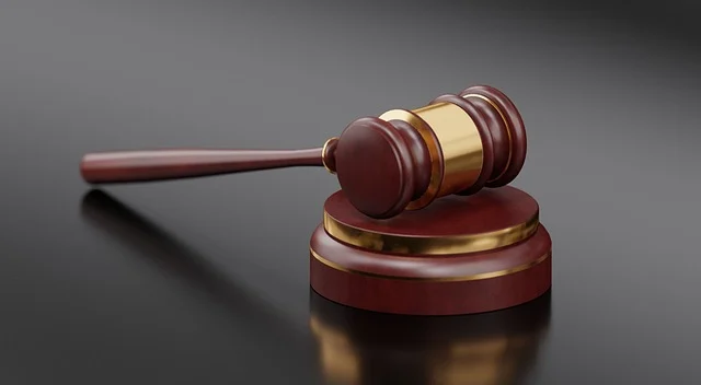 A wooden judge's gavel resting on a sound block