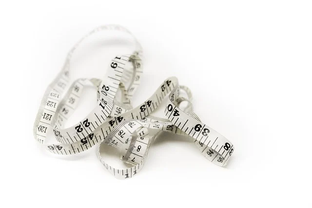 A white measuring tape on a plain background