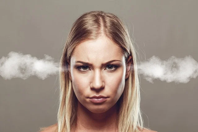 A stressed woman with steam coming out of her ears