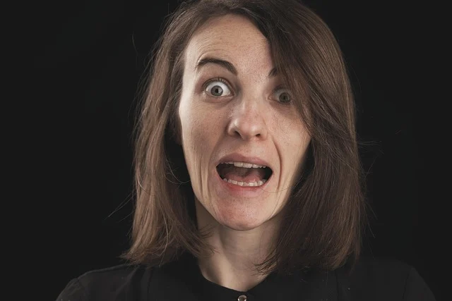 A close-up portrait of a woman with a shocked expression