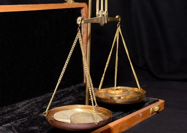 A brass scale with coins sitting on the pans