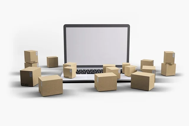 A laptop surrounded by small cardboard shipping boxes