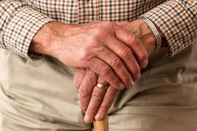 Close-up of a hand applying cuticle oil to almond-shaped nails.