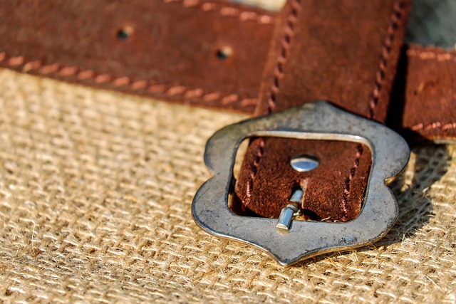 Close-up of a YSL belt buckle featuring the iconic Cassandra logo