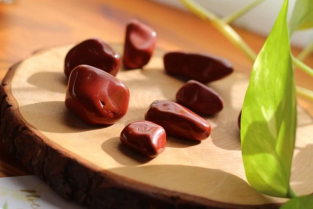 Astrology and Gemstones: Connecting Zodiac Signs to Crystals: Polished red gemstones on a wooden slice
