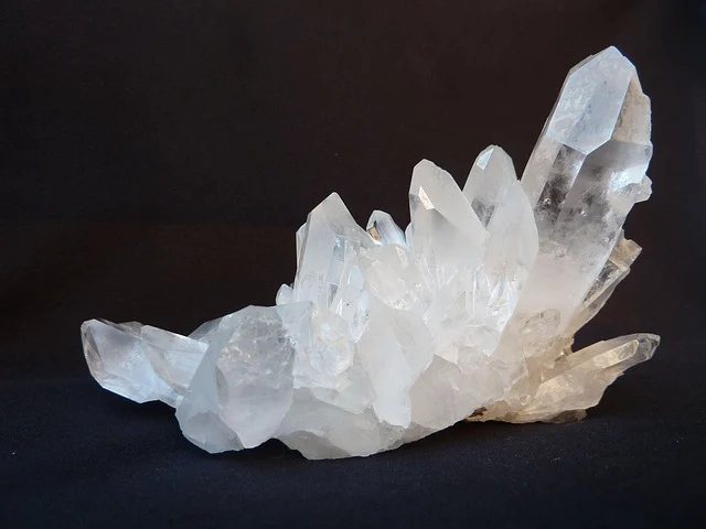 Clear quartz crystal cluster on a dark background