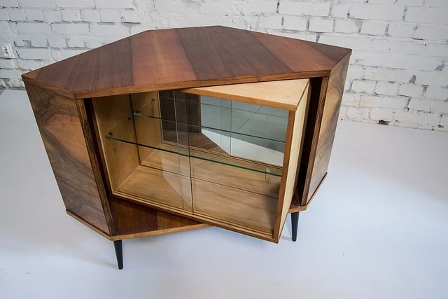 A wooden display cabinet with glass shelves