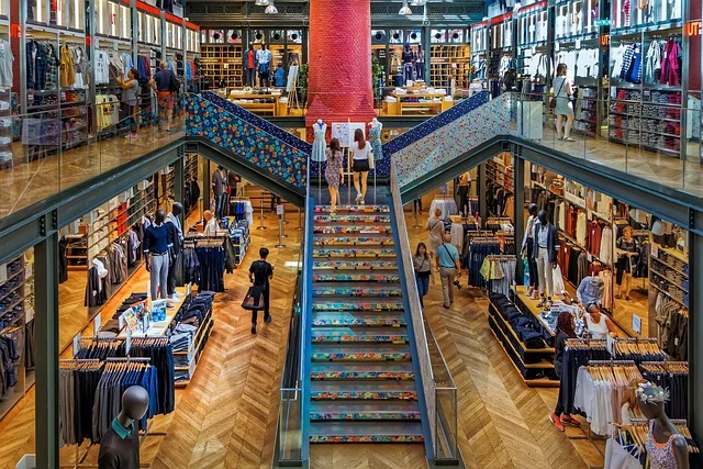 Interior of a multi-story clothing store with racks and shoppers