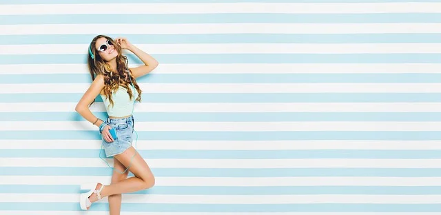 Shorts levis 501: A woman wearing denim shorts posing against a striped background