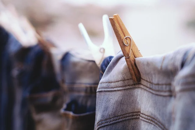 Denim clothing hanging on a clothesline with clothespins to air dry