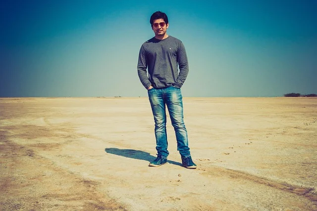 A man wearing fitted blue jeans in a desert
