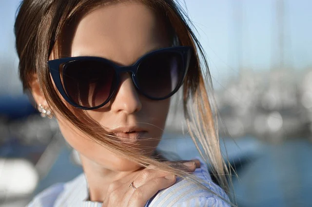 A woman wearing dark cat-eye sunglasses