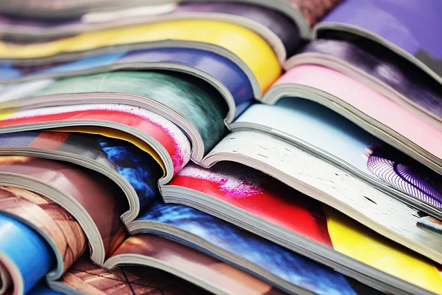 Close-up of open colorful magazines stacked together