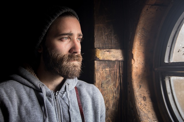 Man looking in mirror at his crew cut, assessing growth