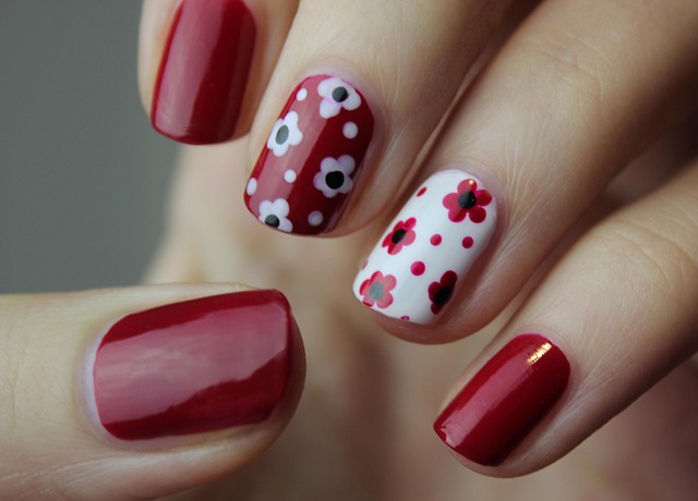 Nail technician using a sponge to create a French ombre effect on a nail.
