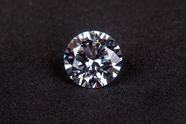 A loose round brilliant cut diamond on a dark surface