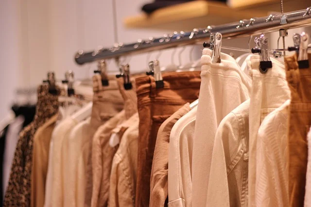 Stussy vs bape: Clothes hanging on a rack in a clothing store