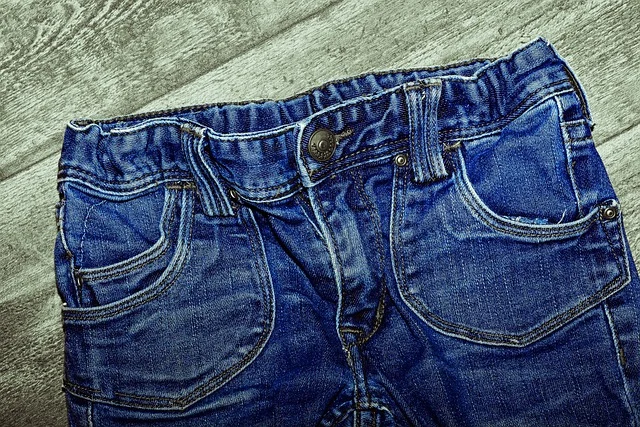 Close-up of the front waistband and pockets of blue denim jeans
