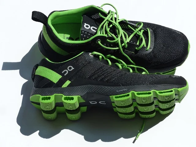 A pair of black and bright green On Running athletic shoes