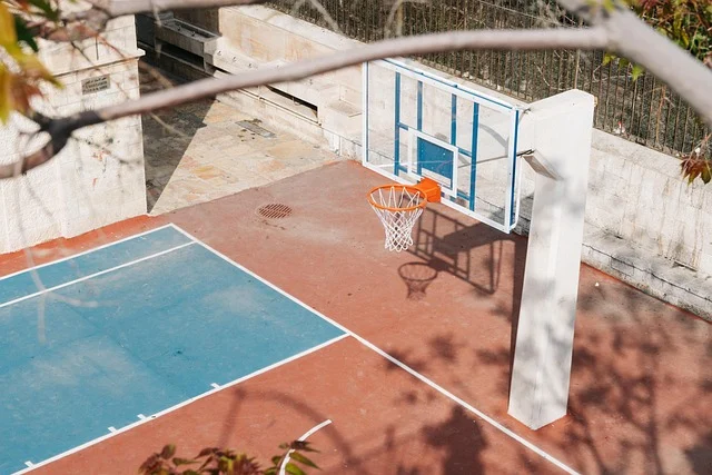 An outdoor basketball court with a hoop and backboard