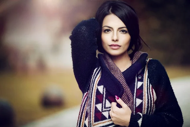 What is quiet luxury: A woman wearing a cozy patterned sweater and dark cardigan outdoors