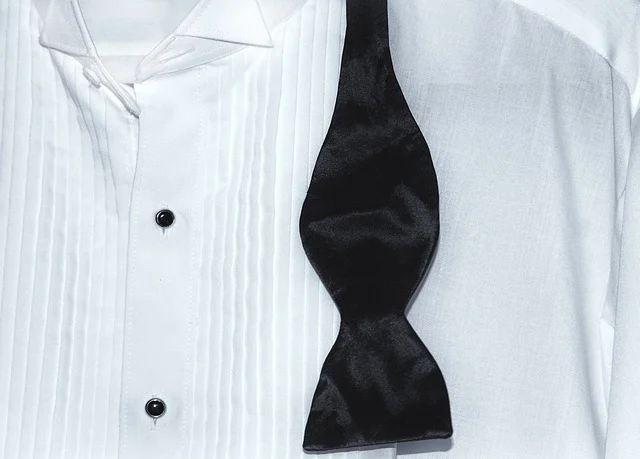A white tuxedo shirt with an untied black bow tie
