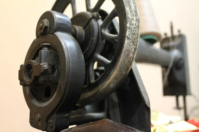 A close-up of a vintage sewing machine wheel and mechanism
